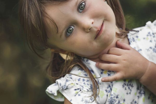 A young girl with blue eyes and pigtails smiles